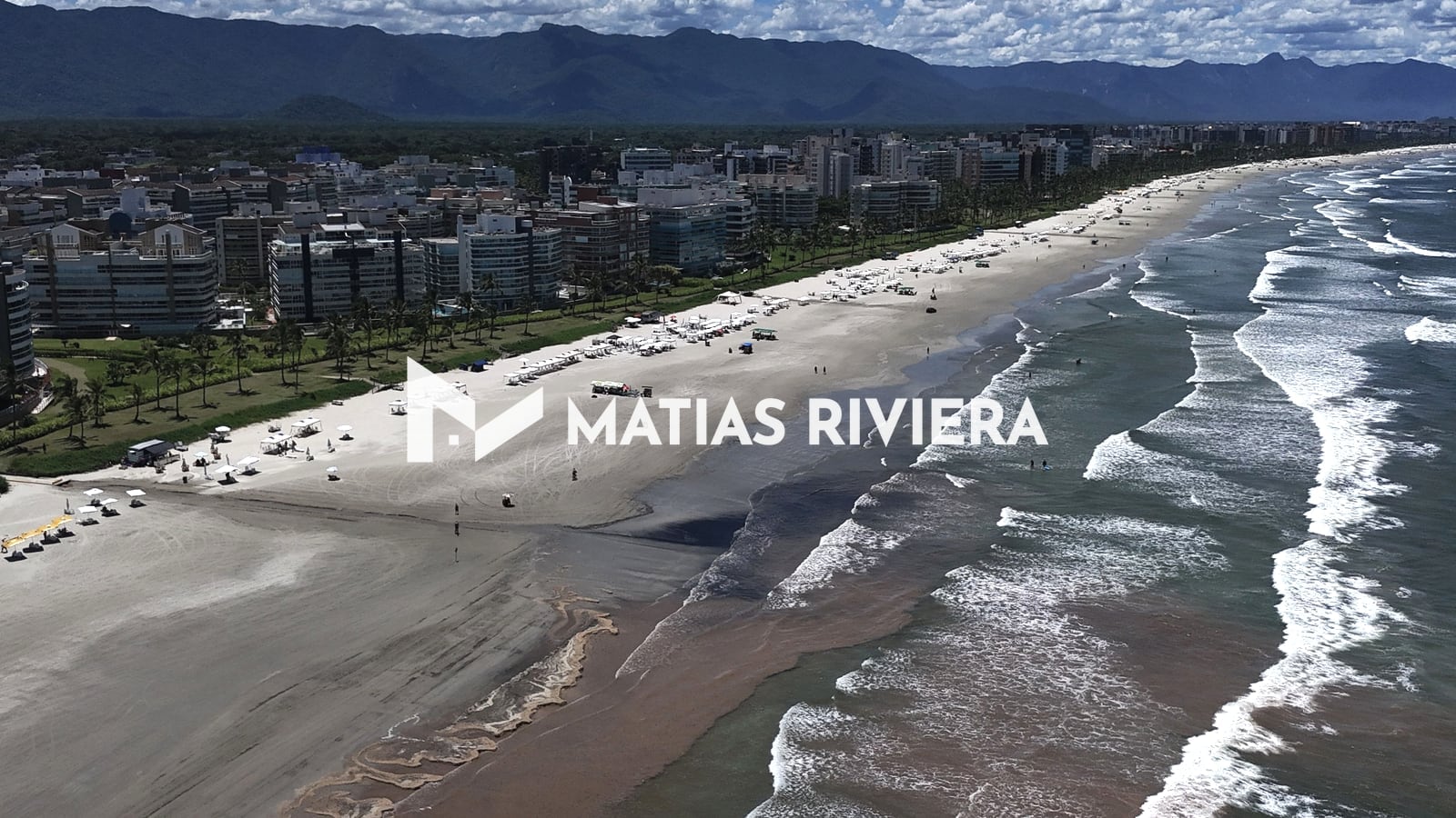 Orla da Riviera de São Lourenço com edifícios da beira-mar, faixa de areia e ondas, vista do alto