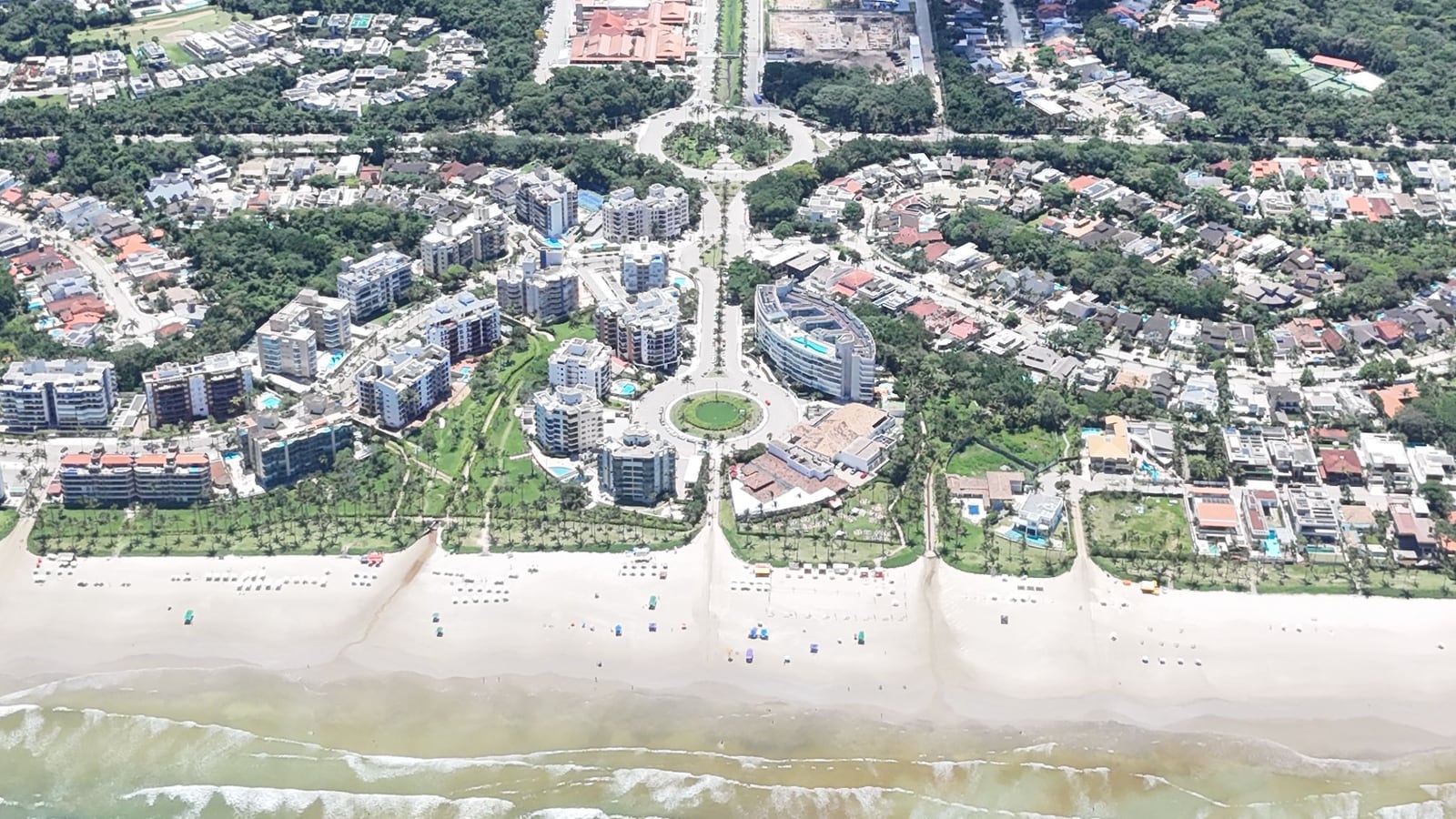 Módulos residenciais e avenida arborizada da Riviera de São Lourenço, vistos do alto a partir da praia