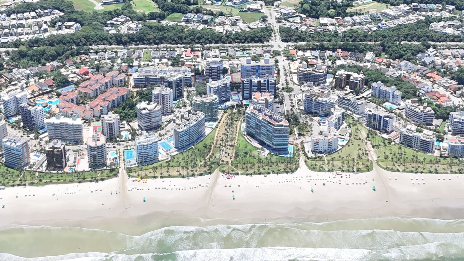 Faixa de areia e módulos residenciais da Riviera de São Lourenço vistos do alto em dia claro
