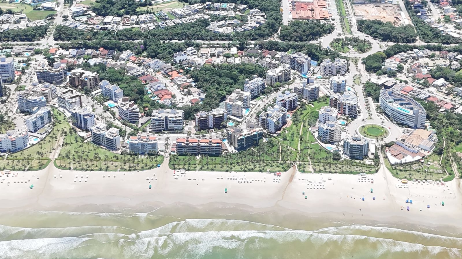 A orla da Riviera de São Lourenço vista do alto, com a praia, os edifícios e os módulos até a mata