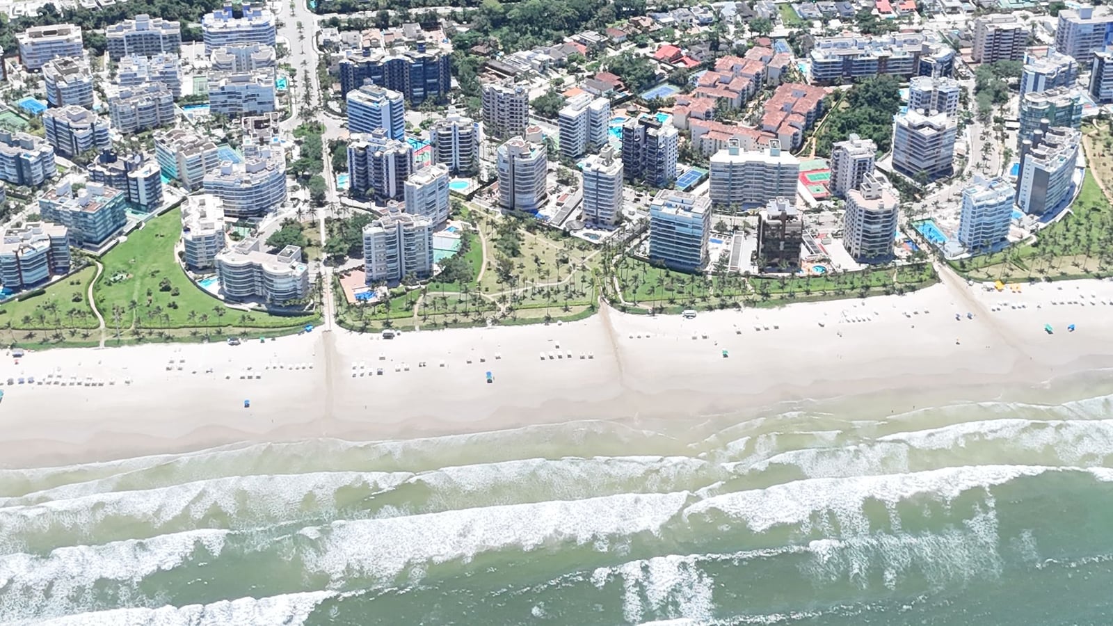 Edifícios e casas dos módulos da Riviera de São Lourenço vistos do alto, entre a praia e a mata