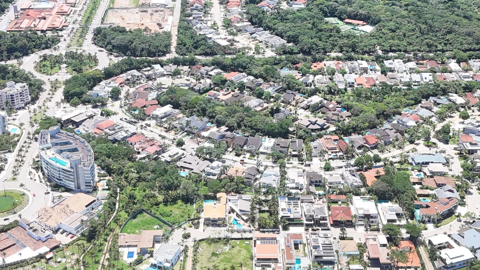 Módulos residenciais da Riviera de São Lourenço vistos do alto, com casas, edifícios, avenidas arborizadas e a praia