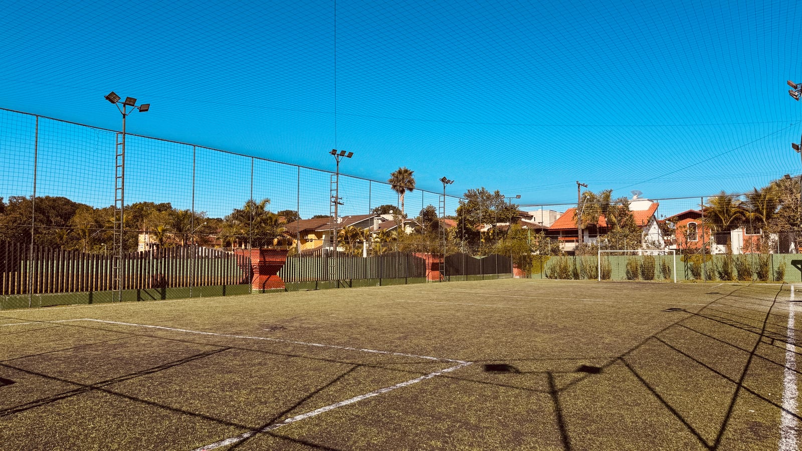 Quadra esportiva com alambrado e iluminação na área comum do Condomínio Hanga Roa