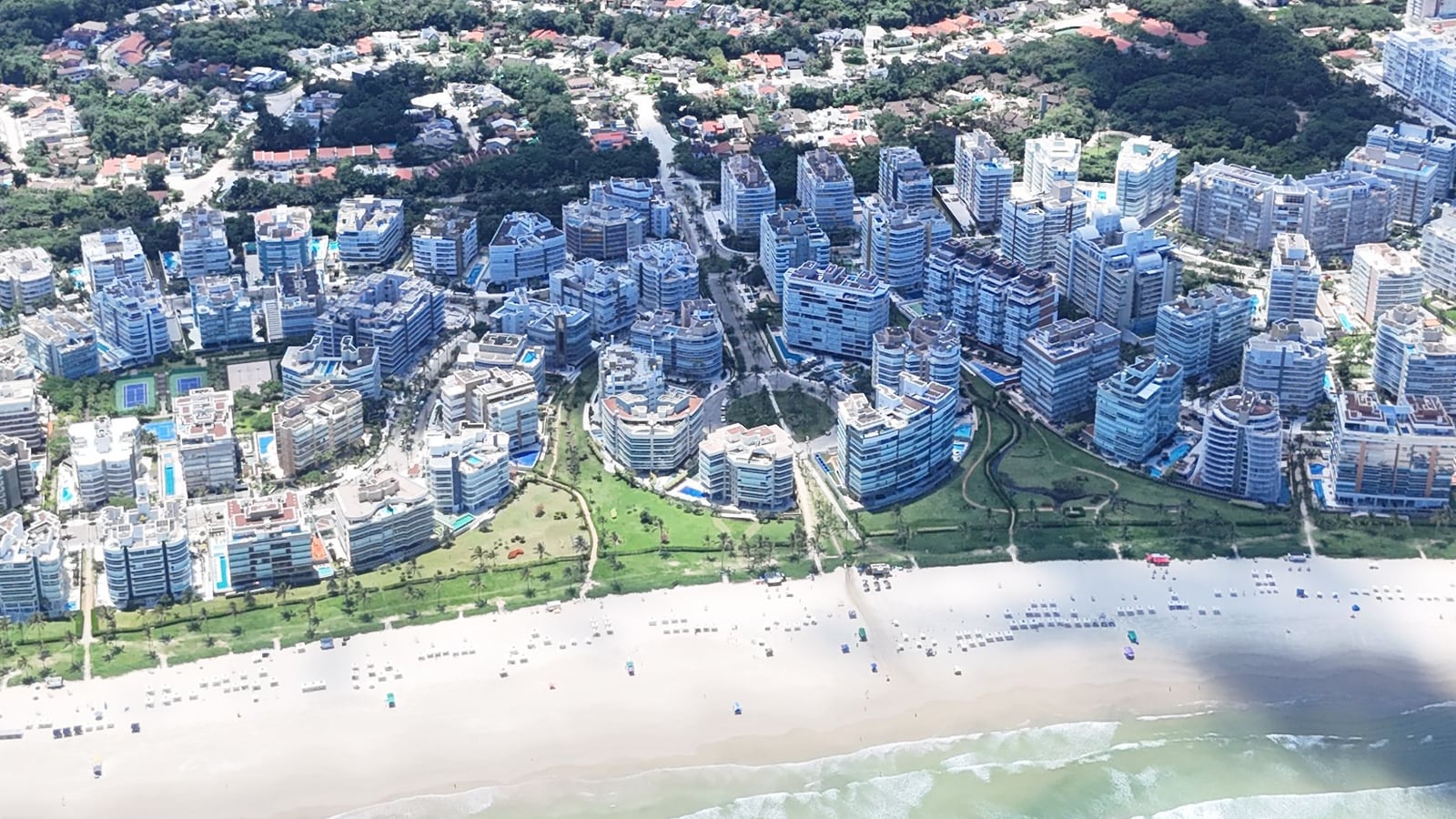 Edifícios da orla da Riviera de São Lourenço vistos do alto, com a praia, os módulos residenciais e a mata ao fundo