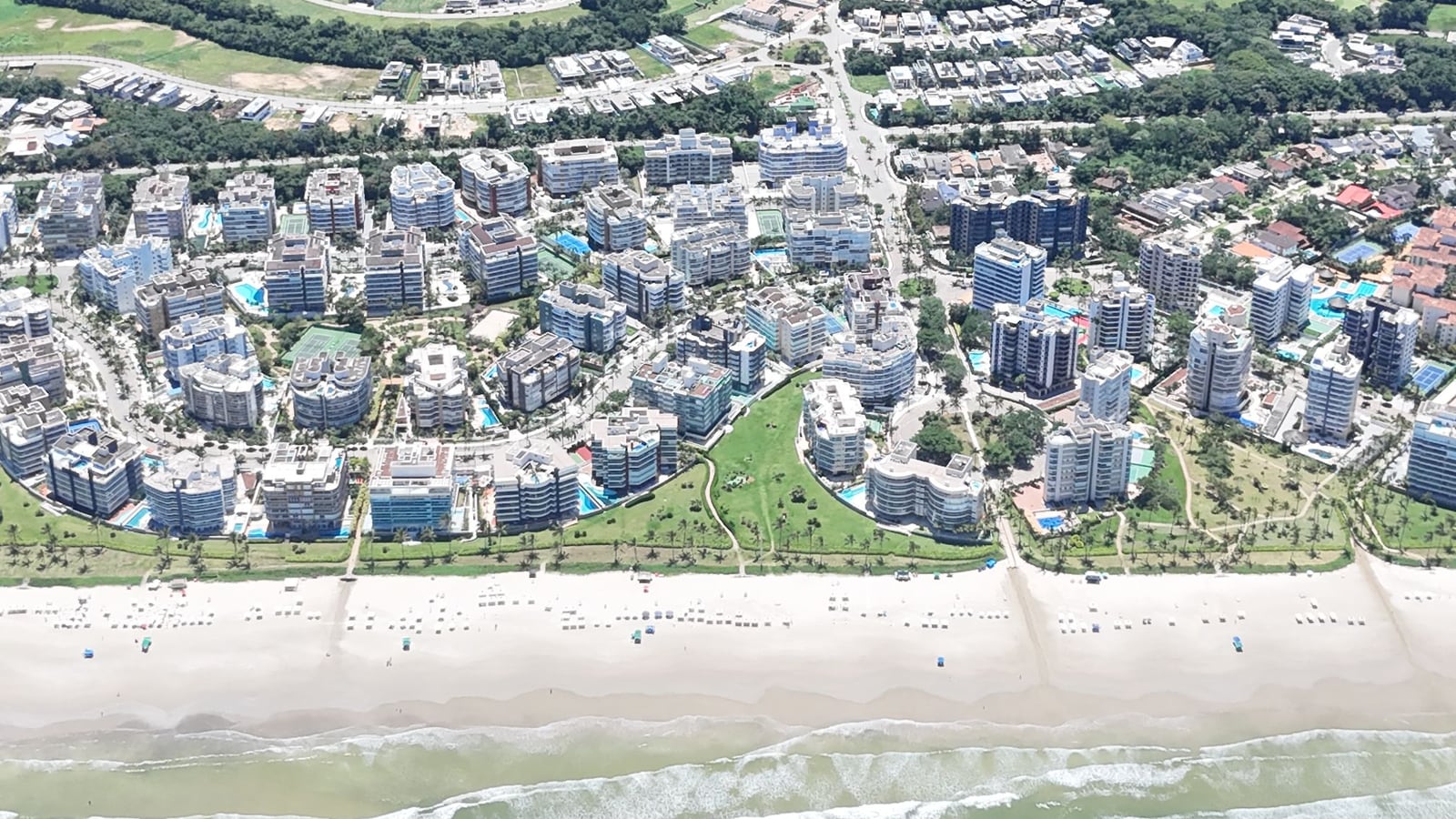 Vista aérea dos módulos da Riviera de São Lourenço junto à praia, com as áreas verdes e a mata ao fundo