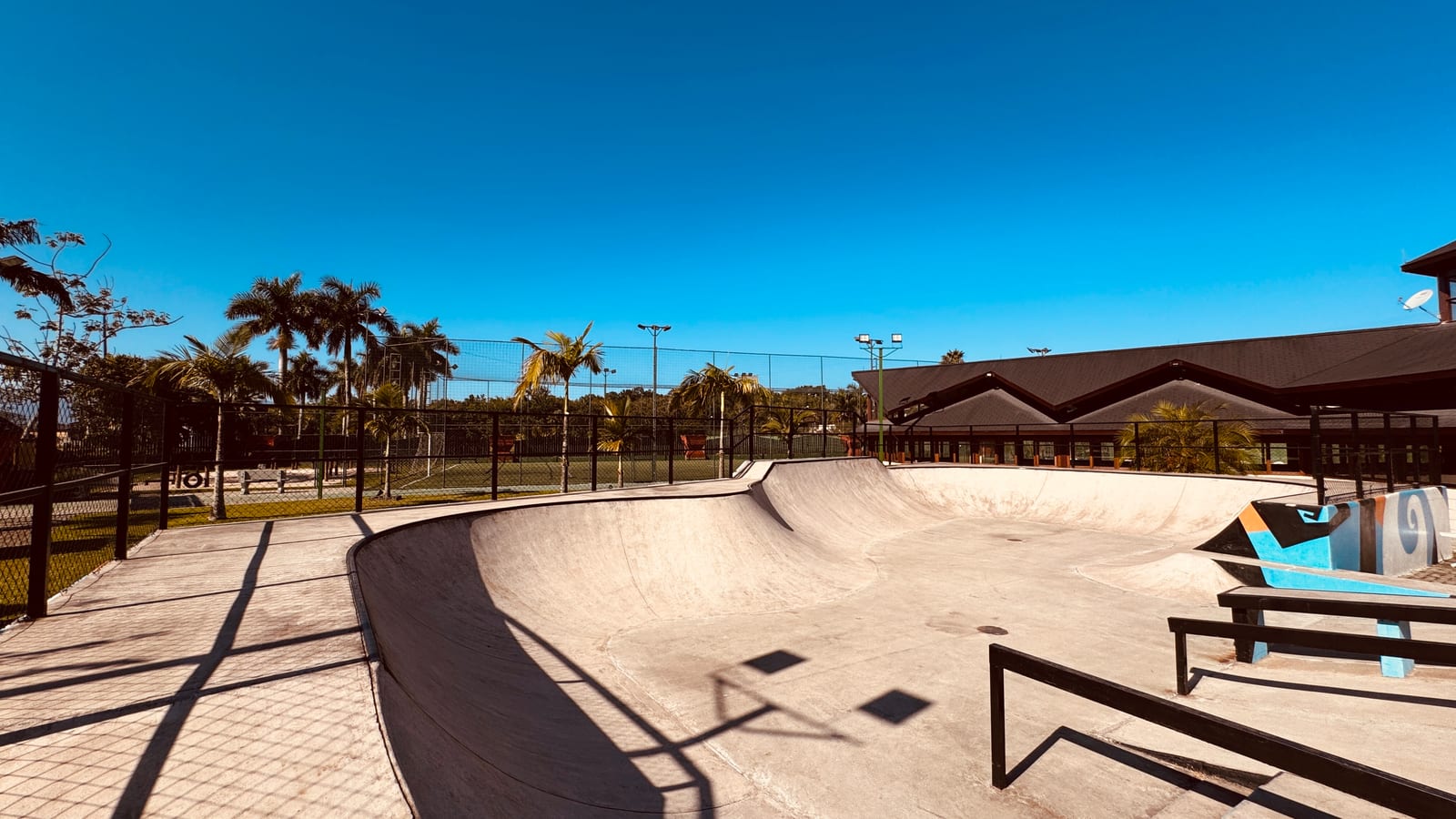 Pista de skate do Condomínio Hanga Roa vista de cima, com o clube e as palmeiras ao fundo