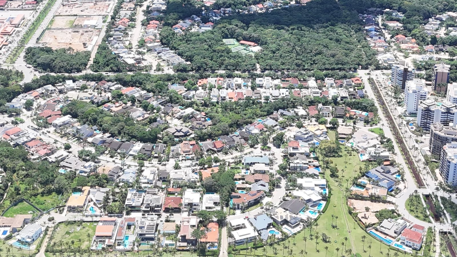 Casas e edifícios da Riviera de São Lourenço vistos do alto, entre a praia e a mata