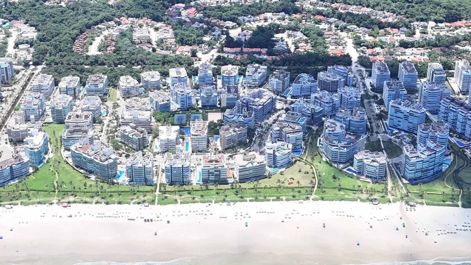 Orla da Riviera de São Lourenço vista do alto, com a praia, os edifícios e a serra no horizonte