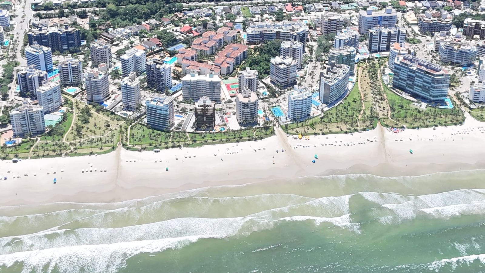 Vista aérea da Riviera de São Lourenço a partir do mar, com a faixa de areia, os edifícios e os módulos residenciais