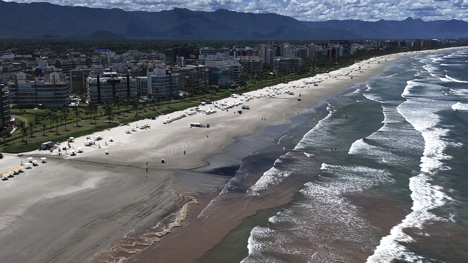 Orla da Riviera de São Lourenço com edifícios da beira-mar, faixa de areia e ondas, vista do alto