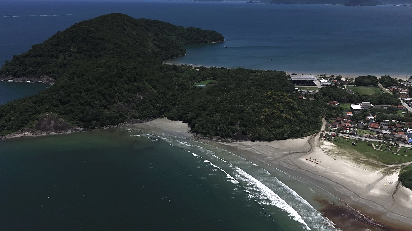 Morro coberto de mata na ponta da praia de São Lourenço, com a restinga e o mar, visto do alto